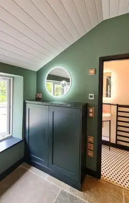 a room with green walls and a round window at The Pigsty & Spa Garden at Tregoose Old Mill in Newquay