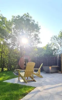two yellow chairs and a picnic table in a yard at The Pigsty & Spa Garden at Tregoose Old Mill in Newquay