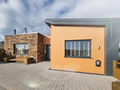 a building with an orange wall and a window at Littlecroft, Hollywell Bay by Together Travel - Luxury Seaside Cottage Retreat in Holywell Bay
