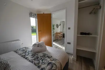 a bedroom with a bed with towels on it at Olverstone Lodge, a beautiful Cornish lodge with wood burner & garden in St Austell