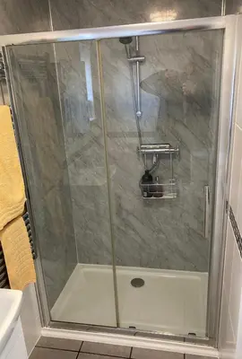 a shower with a glass door in a bathroom at Twin Gates Annexe in Falmouth