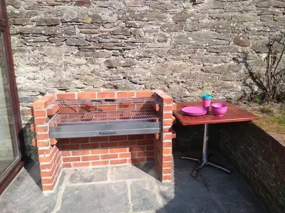 a brick barbecue with a table next to a brick wall at Super Spacious Country house pet/party friendly. in Newquay