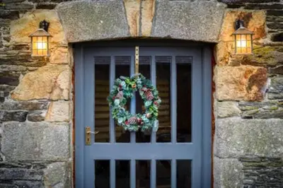 a door to a stone building with a wreath on it at Super Spacious Country house pet/party friendly. in Newquay