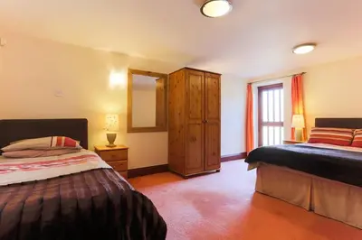 a bedroom with two beds and a large window at Super Spacious Country house pet/party friendly. in Newquay