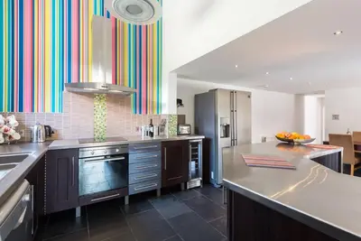 a kitchen with a large counter and a colorful wall at Super Spacious Country house pet/party friendly. in Newquay