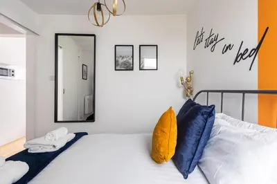 a bedroom with a bed with blue pillows and a mirror at 