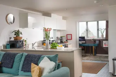 a kitchen and living room with a couch and a counter at Penthouse 53 Zinc - Sleeps 8 in Newquay