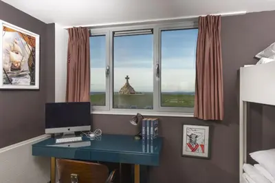 a desk with a computer in a room with windows at Penthouse 53 Zinc - Sleeps 8 in Newquay