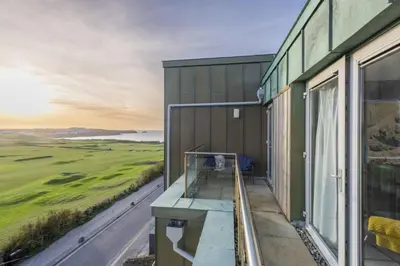 a balcony of a building with a view of a golf course at Penthouse 53 Zinc - Sleeps 8 in Newquay