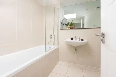 a white bathroom with a shower and a sink at Penthouse 53 Zinc - Sleeps 8 in Newquay