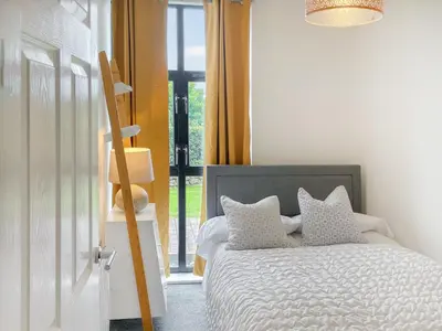 a bedroom with a bed with pillows and a window at Number Six in St Austell