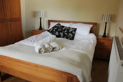 a bed with towels and pillows on it at Kiddlywink Cottage in Saint Columb Major