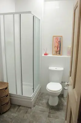a bathroom with a toilet and a glass shower at Kiddlywink Cottage in Saint Columb Major