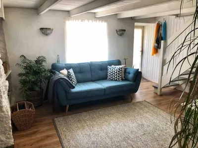a blue couch sitting in a living room at Coombe Cottage in St. Agnes