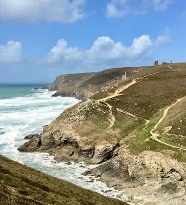 a view of a hill with the ocean and a road at Coombe Cottage in St. Agnes
