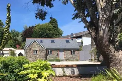 a brick house with a tree in front of it at Gilliflower 1 bedroom cottage at Trethwale Barns Holiday Home in Saint Keyne