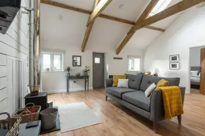 a living room with a gray couch in a room at Gilliflower 1 bedroom cottage at Trethwale Barns Holiday Home in Saint Keyne