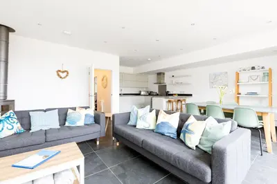 a living room with two couches and a table at The Beach House in Wadebridge