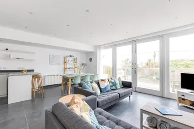 a living room with a couch and a table at The Beach House in Wadebridge