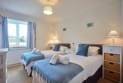 a bedroom with two beds with towels on them at Little Seawynds in Port Isaac