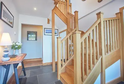 a wooden staircase in a home with a desk at Little Seawynds in Port Isaac