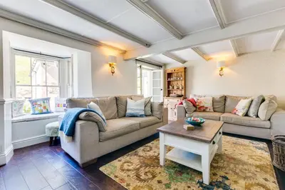 a living room with two couches and a table at Luxury Fisherman’s Cottage Historic Port Isaac in Port Isaac