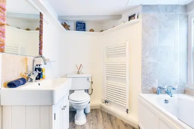a bathroom with a toilet and a sink and a tub at Luxury Fisherman’s Cottage Historic Port Isaac in Port Isaac