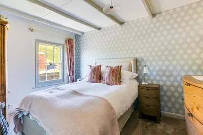 a bedroom with a bed and a window at Luxury Fisherman’s Cottage Historic Port Isaac in Port Isaac