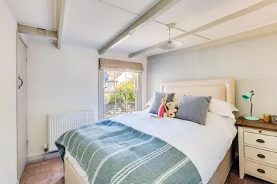 a bedroom with a bed with a teddy bear on it at Luxury Fisherman’s Cottage Historic Port Isaac in Port Isaac
