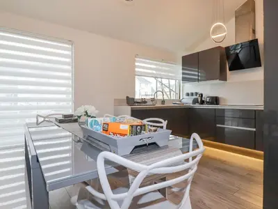 a kitchen with a glass table with chairs and a counter at 10 Quay Court in Newquay