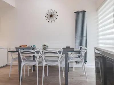 a dining room with a black table and white chairs at 10 Quay Court in Newquay