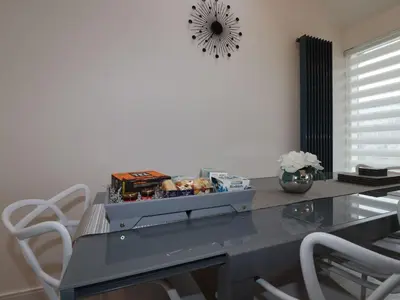 a dining room table with chairs and a clock on the wall at 10 Quay Court in Newquay