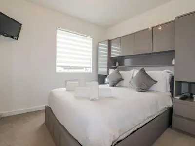 a bedroom with a large white bed with a window at 10 Quay Court in Newquay