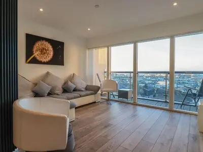 a living room with a couch and floor to ceiling windows at 10 Quay Court in Newquay