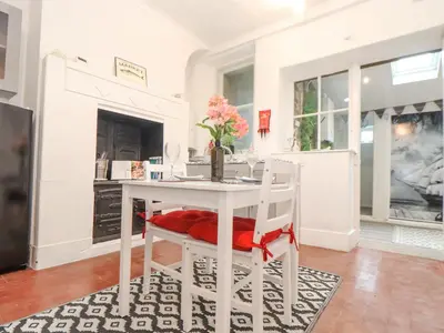 a white dining room with a table and chairs at Little Polgray in St Austell
