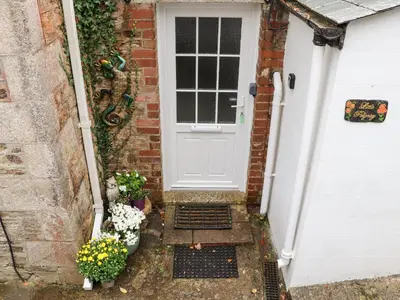 a white door with some plants and flowers at Little Polgray in St Austell