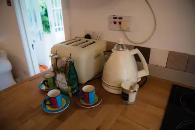 a kitchen with a coffee maker and cups on a table at Lower Hill Cottage w/Swedish Hot Tub in Bodmin
