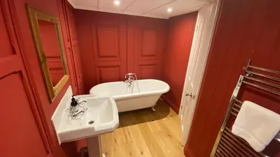a bathroom with a white tub and a sink at Lower Hill Cottage w/Swedish Hot Tub in Bodmin
