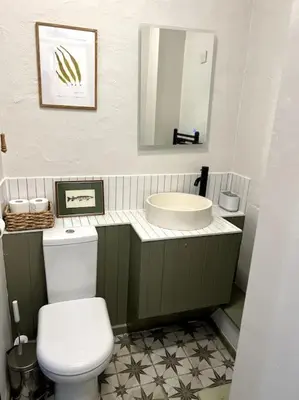 a bathroom with a white toilet and a sink at Bay Tree Barn in Truro