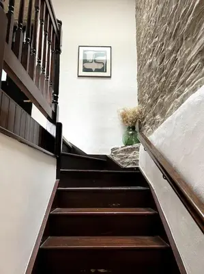 a staircase in a building with a picture on the wall at Bay Tree Barn in Truro