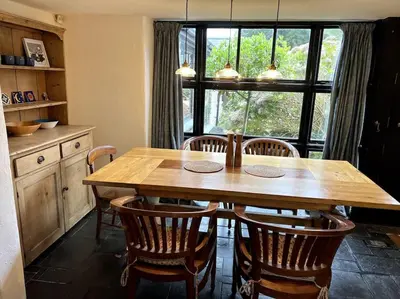 a wooden table and chairs in a kitchen with a window at Bay Tree Barn in Truro