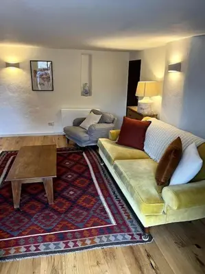 a living room with a couch and a table at Bay Tree Barn in Truro