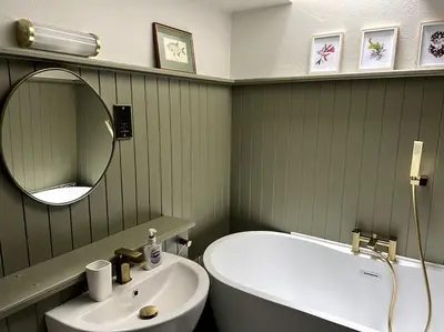 a bathroom with a sink and a tub and a mirror at Bay Tree Barn in Truro