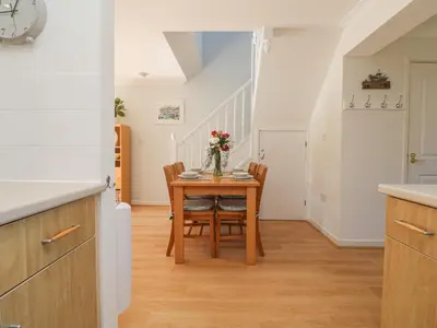 a kitchen and dining room with a table and chairs at Foxglove Cottage in Falmouth