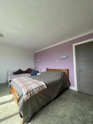 a bedroom with a bed and a purple wall at Amazing house sleeps 13 in Newlyn East