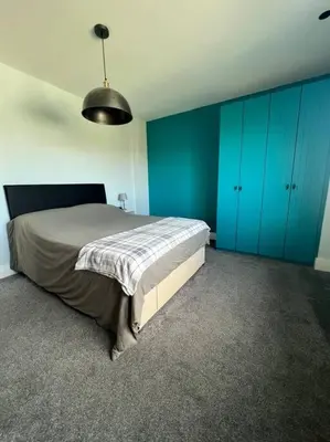 a bedroom with blue cabinets and a large bed at Amazing house sleeps 13 in Newlyn East