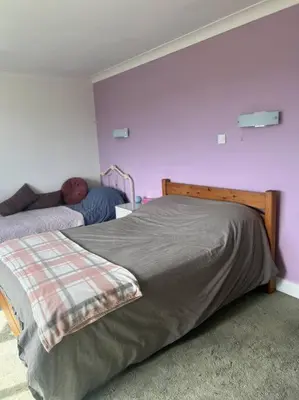 a bedroom with a bed and a purple wall at Amazing house sleeps 13 in Newlyn East