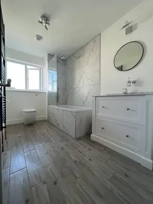 a bathroom with a tub and a sink and a mirror at Amazing house sleeps 13 in Newlyn East