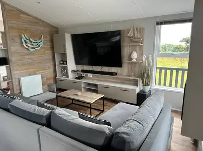 a living room with a couch and a flat screen tv at Modern Lodge with Amazing Views in Newquay