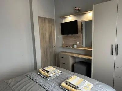 a bedroom with a bed with towels on it at Modern Lodge with Amazing Views in Newquay